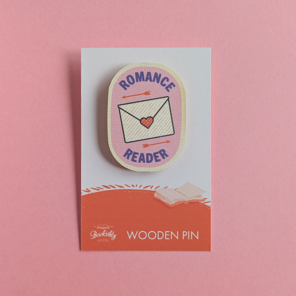 Romance Reader wooden merit badge pin on backing card with pink background