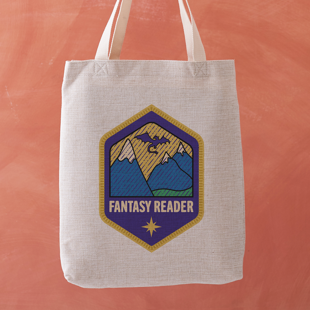Fantasy Reader tote bag with a stitched badge-style design featuring a mountain range illustration on a deep purple background.