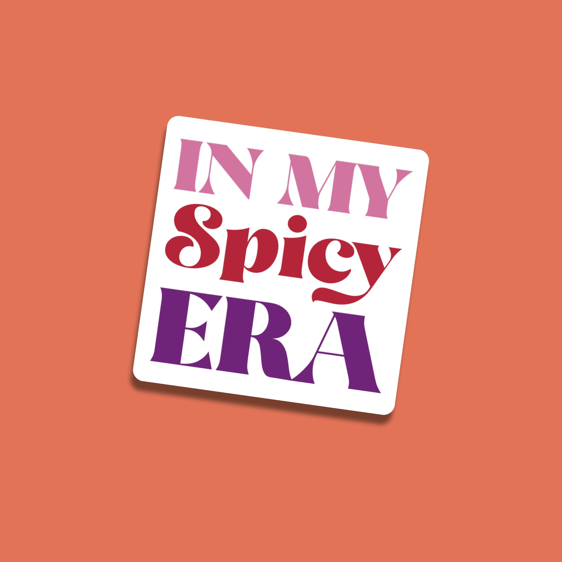 Square sticker with the words “In My Spicy Era” in bold red, pink, and purple lettering on a white background, set against a coral backdrop.
